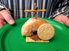 a person holding a green plate with a doughnut and cookie on top of it