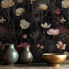 three vases sitting on top of a table next to a wall with flowers painted on it