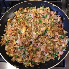 a pan filled with rice and vegetables on top of a stove