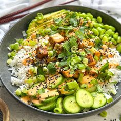 a bowl filled with rice and vegetables on top of a table