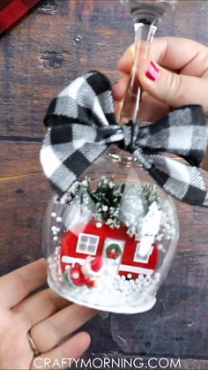 two wine glasses filled with snow and christmas decorations