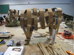 an animal made out of cardboard sitting on top of a table