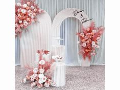 a wedding set up with pink and white flowers on the side, along with an arch