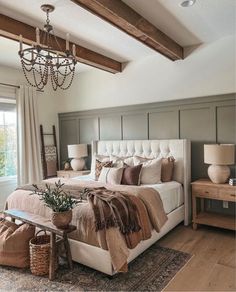 a large bed sitting in a bedroom under a chandelier next to a window