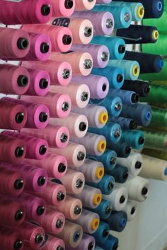 many spools of thread are lined up on a rack