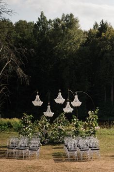 an outdoor ceremony setup with chairs and chandeliers