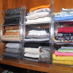 the closet is full of folded clothes and socks on display in clear acrylic bins