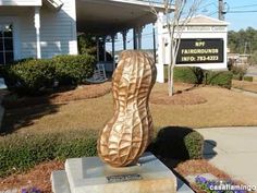 a large wooden shoe sitting on top of a cement block in front of a building