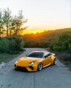 a yellow sports car parked on the side of a road