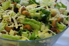 a salad with lettuce, raisins and nuts in a glass bowl