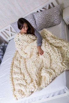 a woman laying in bed under a blanket