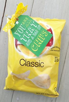 a bag of chips sitting on top of a wooden table next to a yellow bow