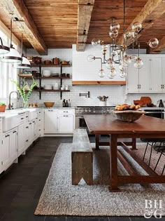 a kitchen with white cabinets and wood ceilinging, an island table in the middle