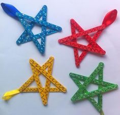 four different colored plastic stars on a white surface with the numbers 3 and 4 below them