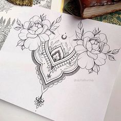 an open book sitting on top of a table next to flowers and bookshelves