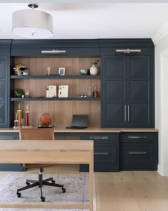 a home office with built in cabinets and desk