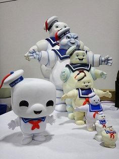 three white stuffed animals standing next to each other on a table