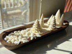 there are three small white trees in the tray on the table next to each other