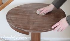 a person is cleaning the top of a wooden table