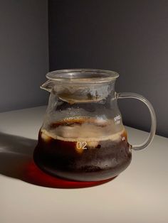 a pitcher filled with liquid sitting on top of a table