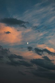 the moon is shining brightly in the cloudy sky