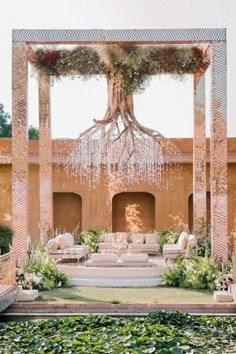 an outdoor living area with couches, tables and water lilies on the ground