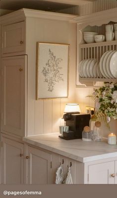 a kitchen with white cabinets and dishes on the shelves