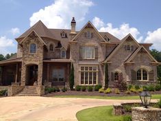 a large brick house with lots of windows and stone steps leading to the front door