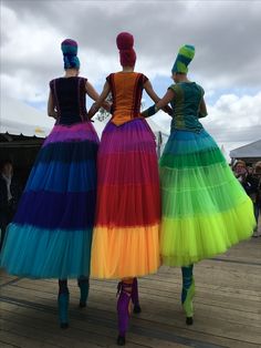 three women in colorful dresses are standing together