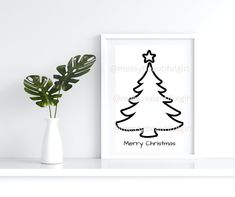 a black and white christmas tree print on a shelf next to a potted plant