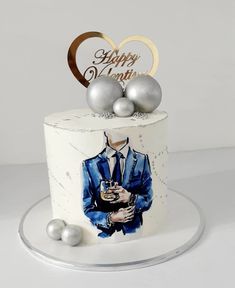 a birthday cake decorated with an image of a man in a suit and two silver balls