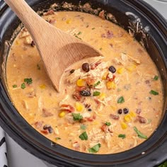 a wooden spoon in a slow cooker filled with soup