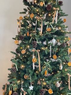 a decorated christmas tree with oranges and pine cones