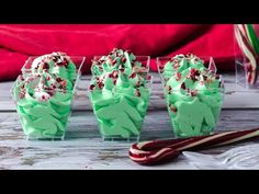 cupcakes with green frosting and sprinkles in small plastic cups