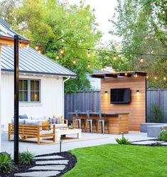 an outdoor living area with patio furniture and string lights