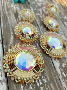 three pieces of beaded jewelry sitting on top of a wooden table