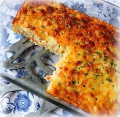 a cheesy casserole on a blue and white plate