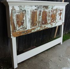 an old dresser is painted white and has rusted paint on it's doors