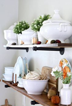 the shelves are filled with dishes and other kitchen items, including pumpkins on them