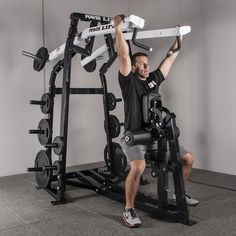 a man is sitting on a bench with his arms in the air while holding up a weight machine