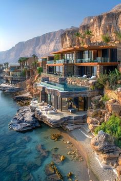 an oceanfront house with a swimming pool in the middle of it, surrounded by rocky cliffs