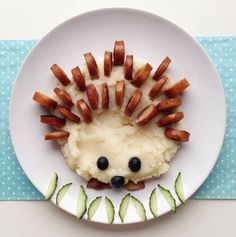 a white plate topped with food on top of a blue and white table cloth next to a fork