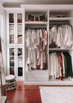 an organized closet with clothes, shoes and other items on it's shelves in a home