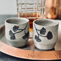 two cups sitting on top of a metal tray