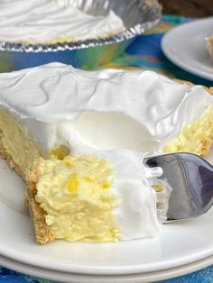 a slice of lemon meringue pie on a white plate with a silver fork