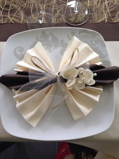 a white plate topped with two napkins and flowers