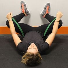 a woman laying on the ground with her feet up in the air while doing exercises