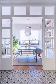 an open door leading to a dining room with a table and potted plant in it