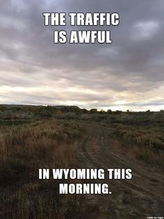 a dirt road in the middle of a field with text over it that reads, the traffic is awful in wyoming this morning