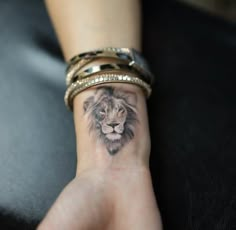 a woman's wrist with a lion tattoo on it